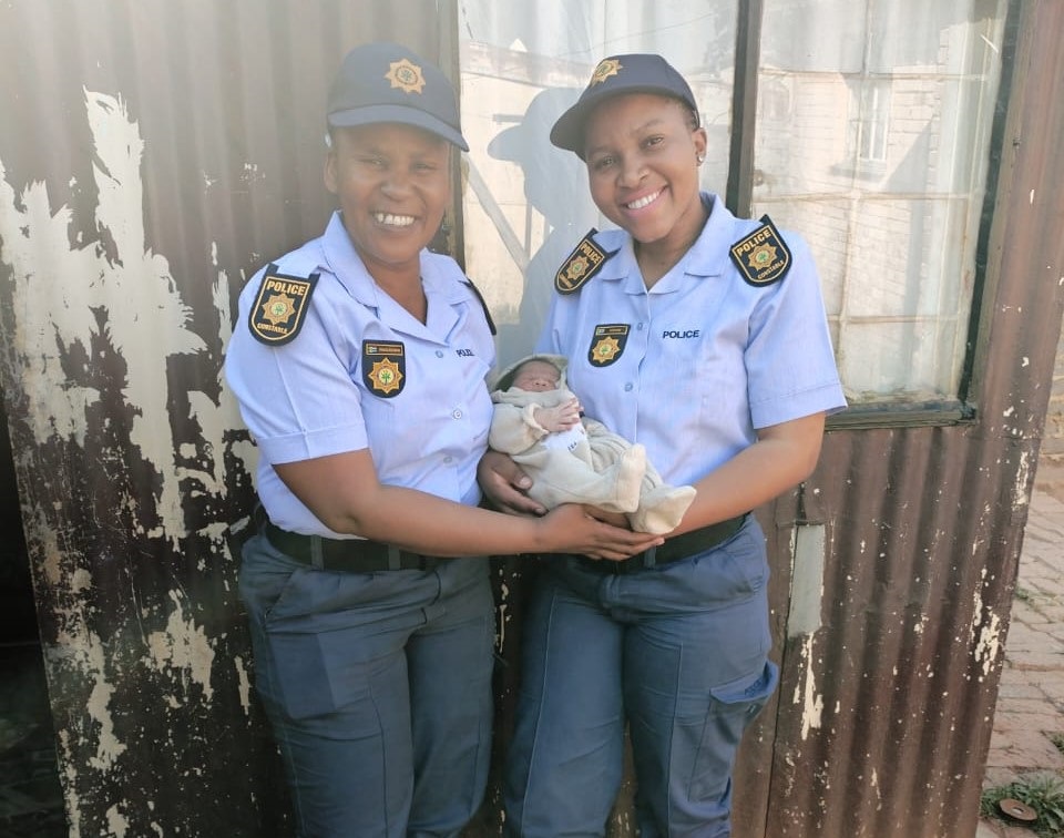 Constable Tsholofelo Hope Ramolahlwane  and Constable Noloyiso Ntsenge with baby Remano Aweries, who they helped to deliver.