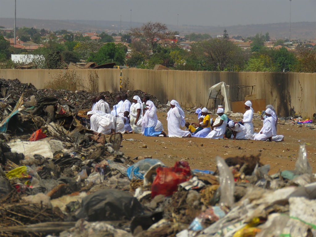 Worshippers praying next to the dumping site along the Soutpan road. Photo by Ntebatse Masipa