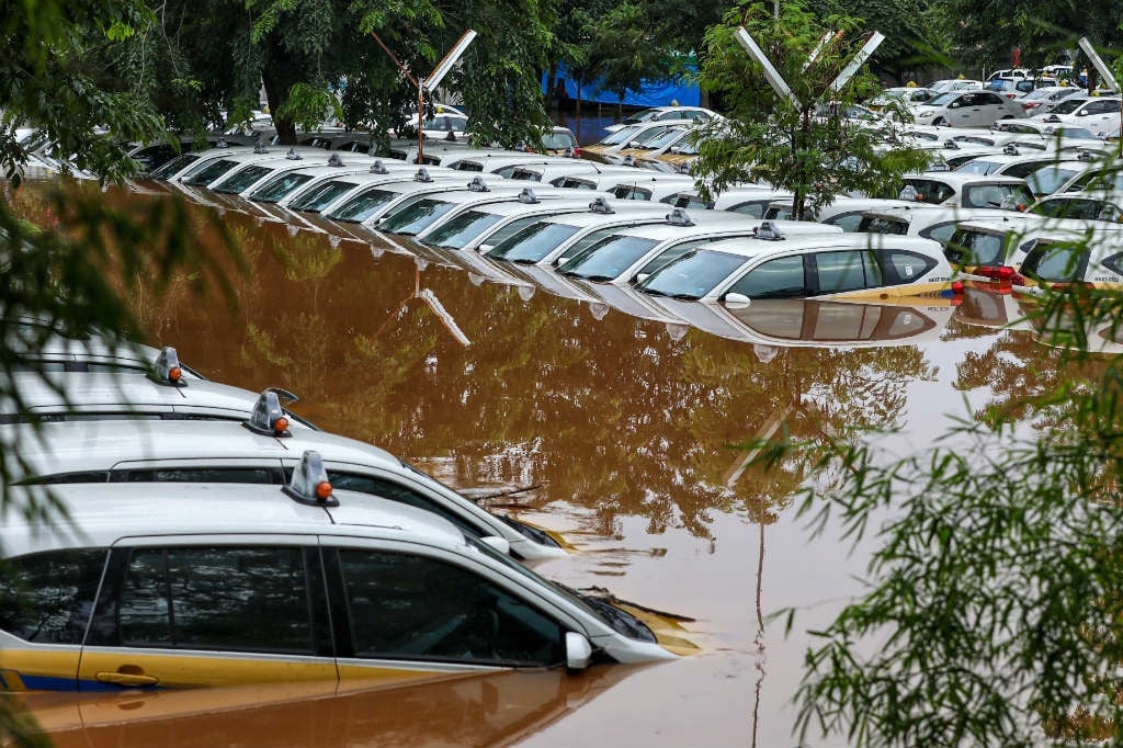 A fleet of flooded taxis are seen at the operator's submerged parking lot following overnight rain in Jakarta on January 1, 2020. (Ralia/AFP)