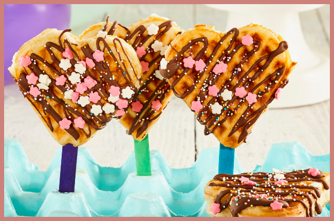 Waffles on a stick dipped in melted chocolate sauce