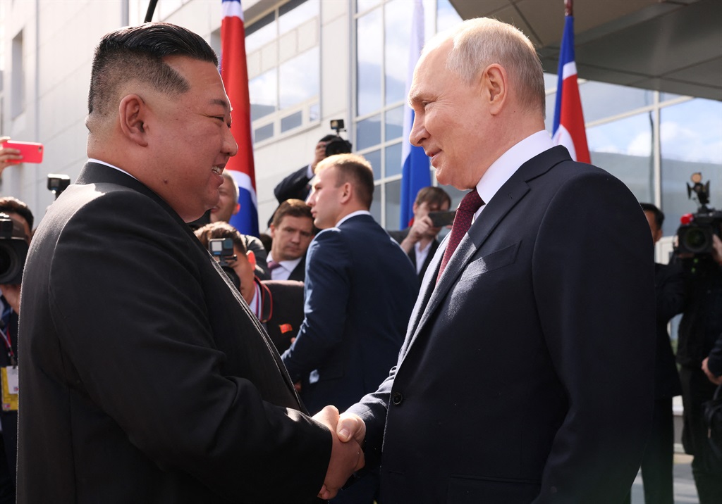 Vladimir Putin shakes hands with Kim Jong Un durin