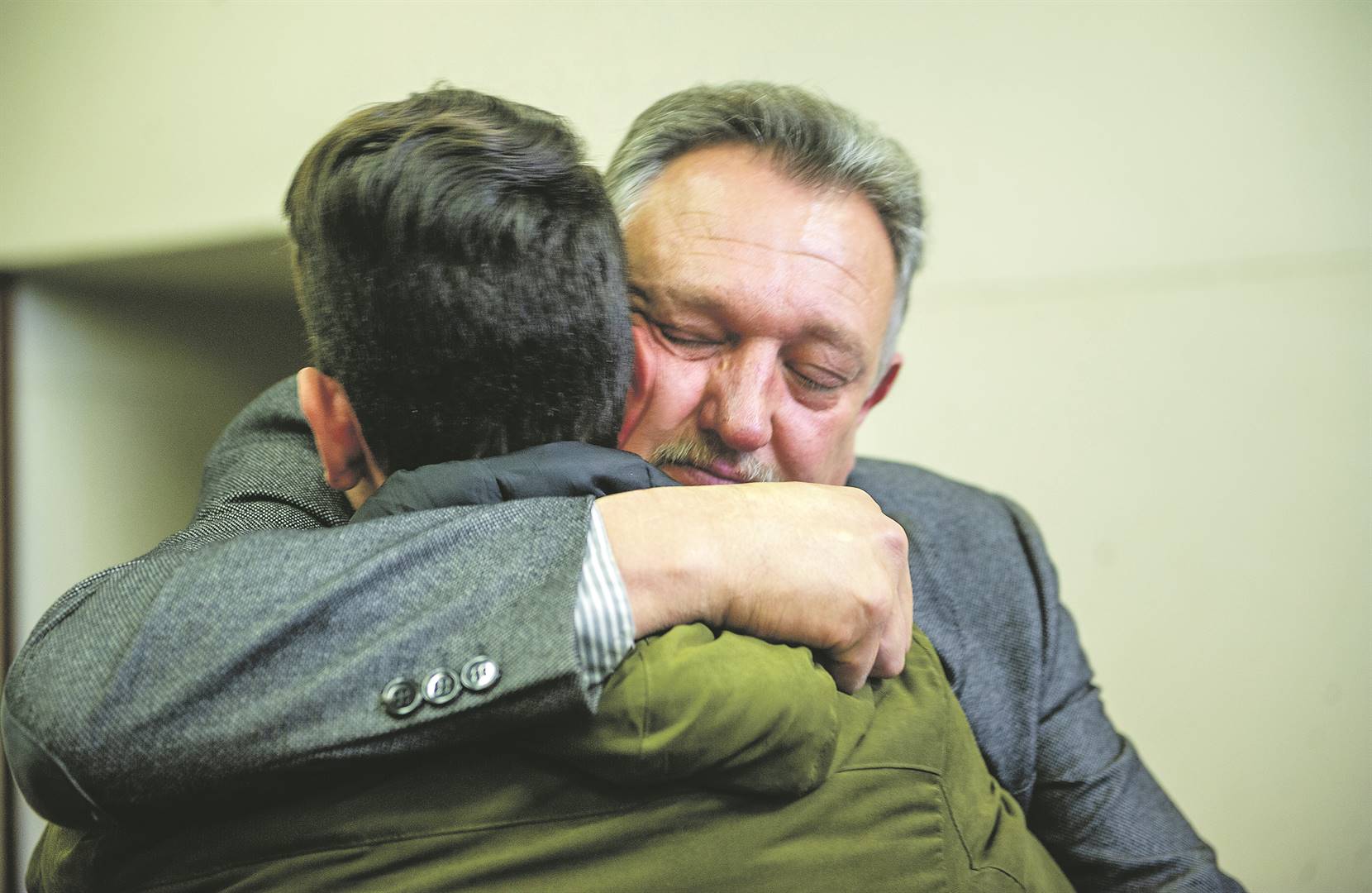 Coert Kruger embraces his other son after being found guilty of murdering his eldest son. (Elizabeth Sejake, Rapport)