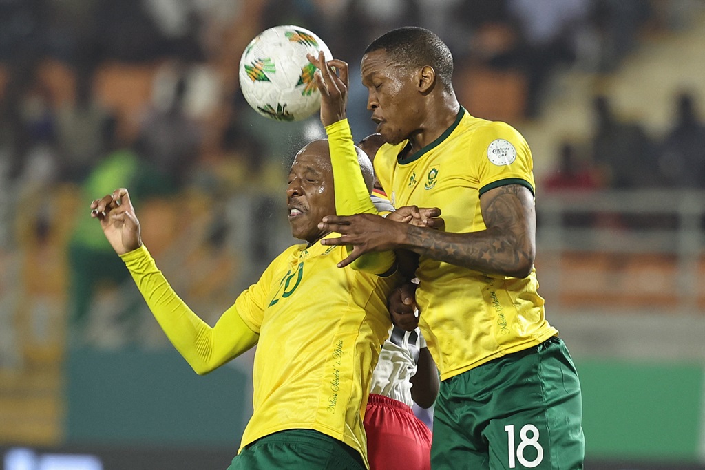 Khuliso Mudau (L) and Grant Kekana (R) jump to head the ball during the Africa Cup of Nations clash between South Africa and Namibia at Amadou Gon Coulibaly Stadium in Korhogo on 21 January 2024.