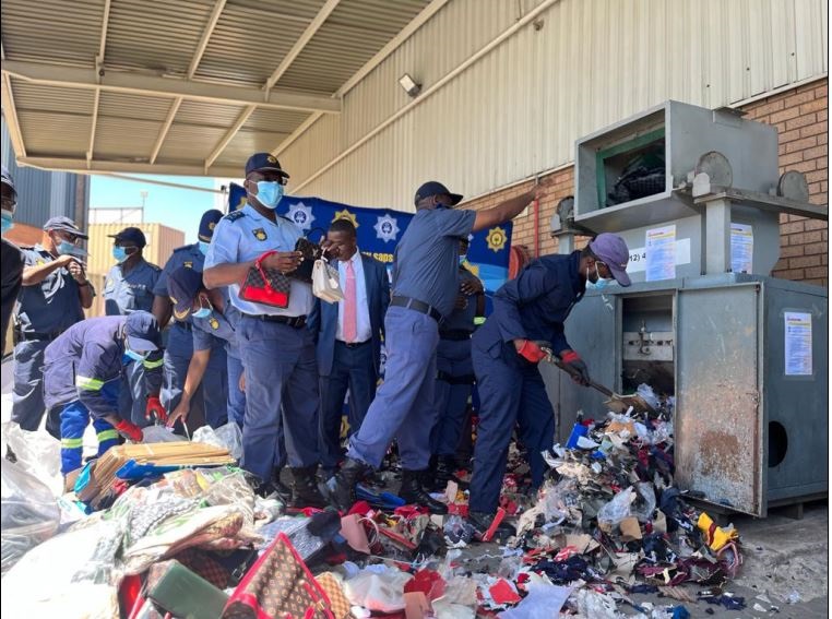 Cops destroying fong kong goods in Clayville. Photo by Mfundekelwa Mkhulisi