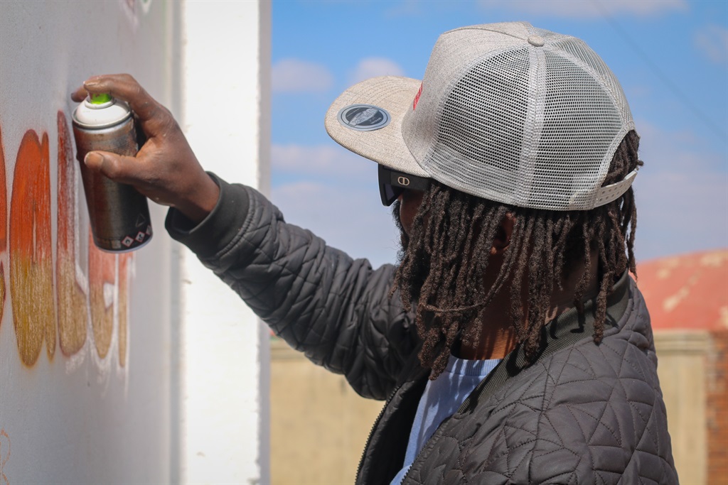 Visual artist Senzo Nhlapo is painting a mural on 