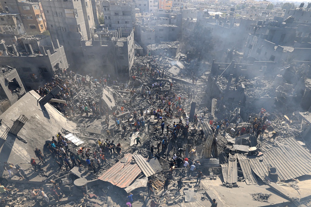 People search for survivors and the bodies of victims through the rubble of buildings destroyed during Israeli bombardment, in Khan Yunis in the southern Gaza Strip on 26 October 2023, amid the ongoing battles between Israel and the Palestinian group Hamas. 