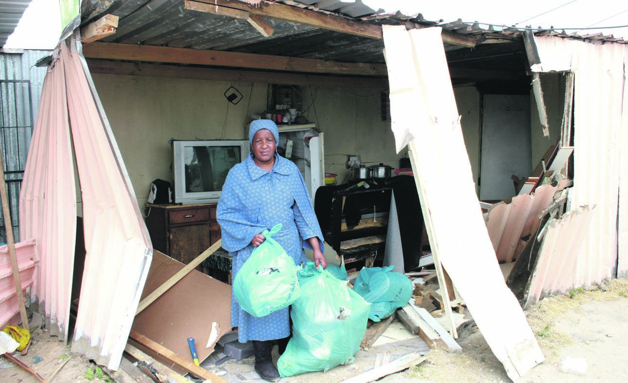 Ntombekhaya Thomas picks up the pieces after a Quantum taxi driver drove into her shack while Ntombekhaya, her daughter and grandchild were sleeping. Photo by Lindile Mbontsi