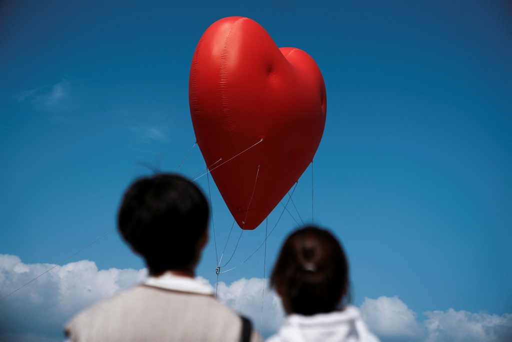 Visitors look at a giant inflatable heart called Chubby Hearts, an installation by designer Anya Hindmarch, on Valentine's Day in Hong Kong, China, on 14 February 2024. 