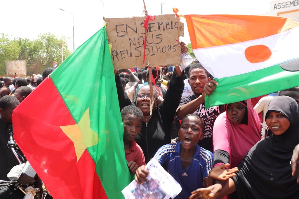 Nigerinos sosteniendo una bandera de Burkina Faso (L) y Níger y un cartel que decía "Juntos lo lograremos".  (Djibo Issifou/Picture Alliance vía Getty Images)