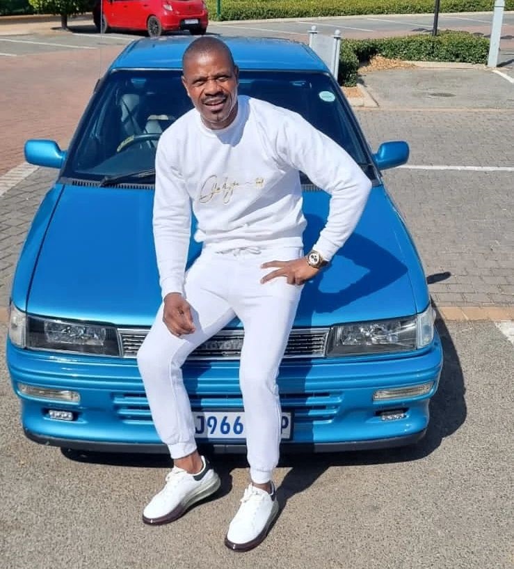 Lucky Lekgwathi posing next to a classic Toyota Conquest. 