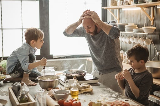 Father with two kids preparing pizza at home