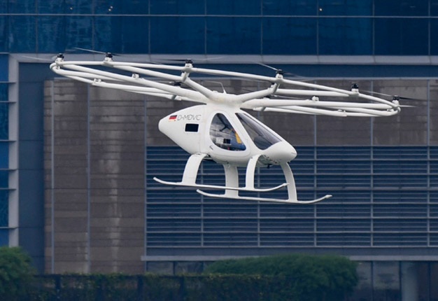 A Volocopter unmanned air taxi transport flies over Marina Bay during test flight with a safety pilot at the 26th Intelligent Transport Systems World Congress (ITSWC) in Singapore on October 22, 2019. (Photo by Roslan RAHMAN / AFP)