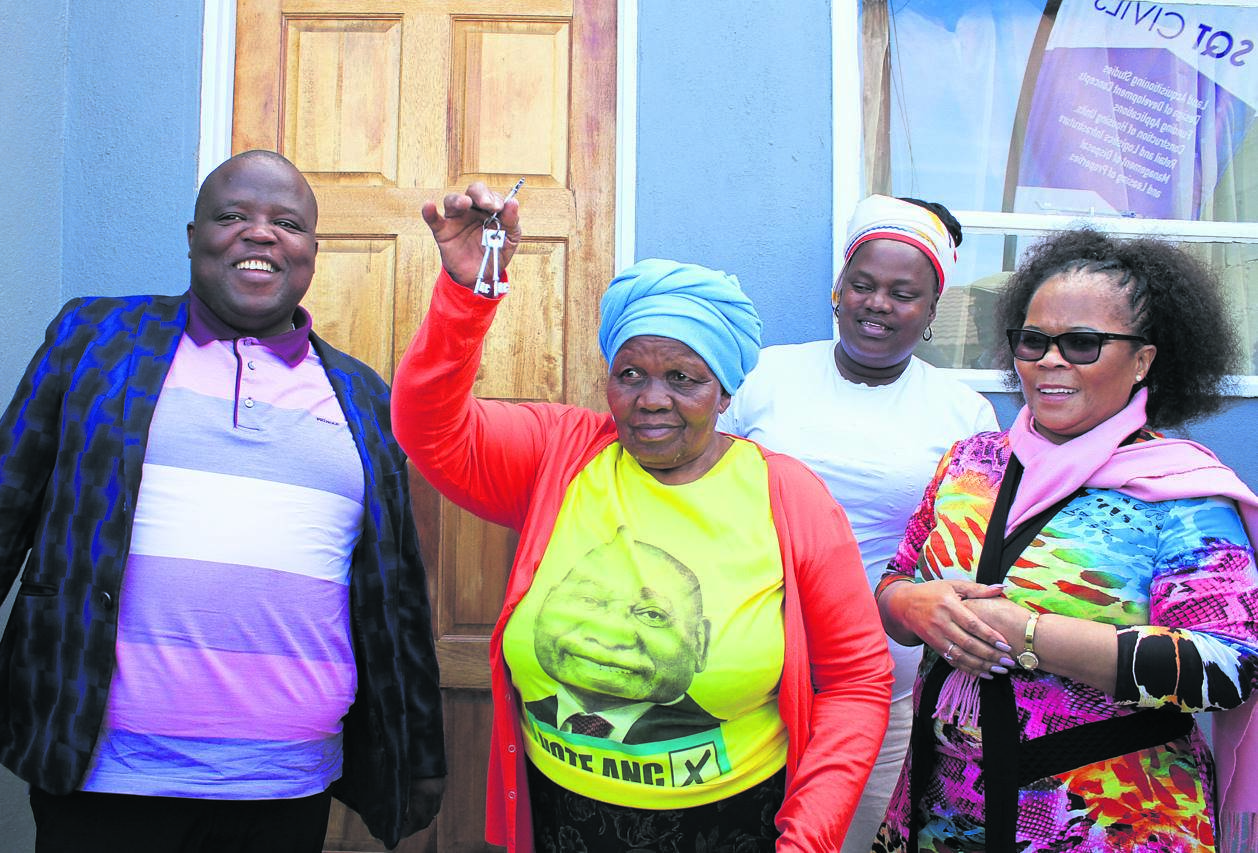 From left, front: Chippa Mpengesi with Maria Lungana outside her house, alongside deputy minister Pam Tshwete.       Photos By Lindile Mbontsi