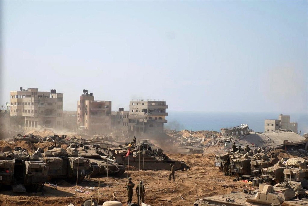 This handout picture released by the Israeli army on 5 November 2023, shows Israeli tanks and soldiers stationed at a location in the northern Gaza Strip as battles between Israel and the Palestinian Hamas movement continue. 