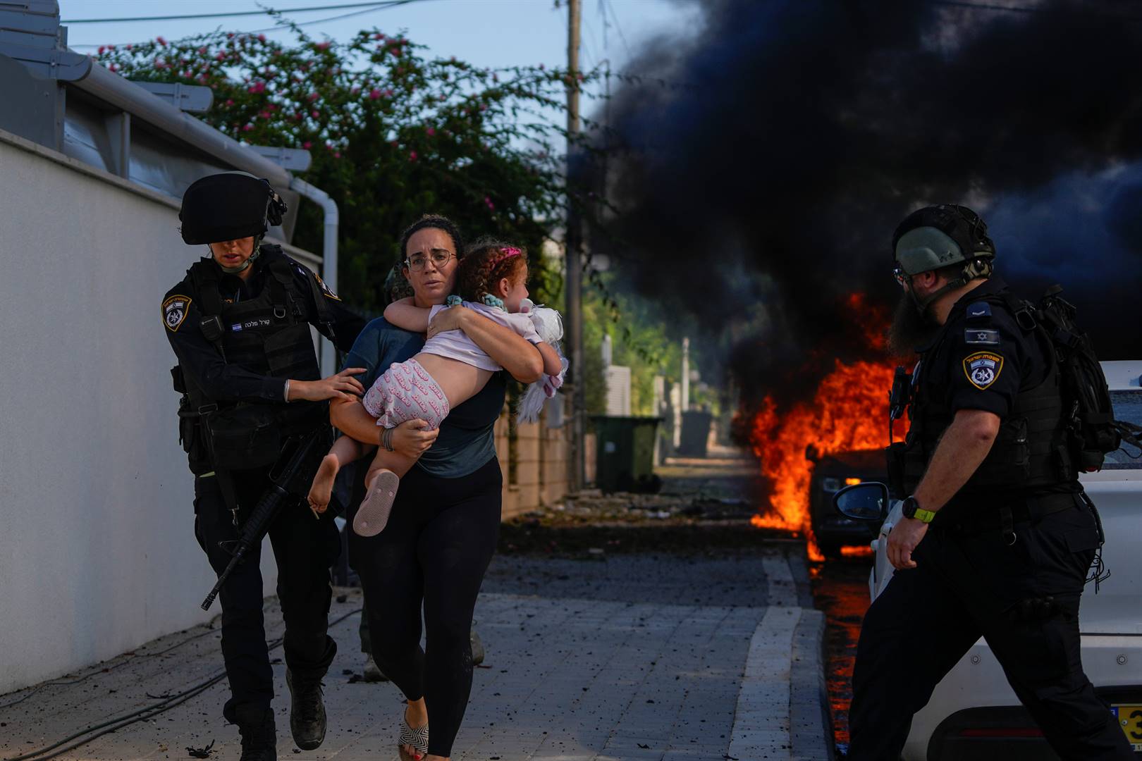 A woman and her child are evacuated by Israeli police after rockets were fired into the country by Hamas from Gaza on Saturday.