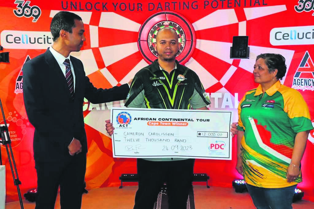 Ward councillor Mikhail Manuel is seen congratulating winner Cameron Carolissen (middle) alongside the managing director for the African Darts Group Nicole Alcock. PHOTOS: Supplied