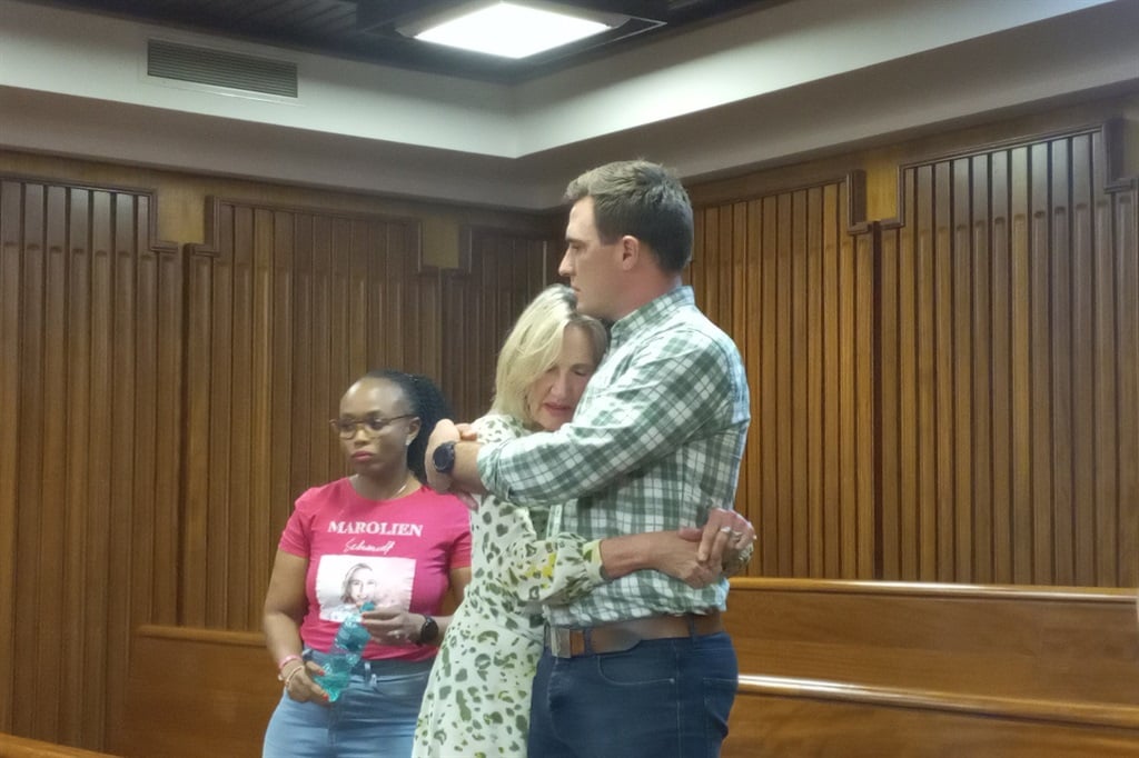 Marolien Schmidt's brother, Casper, consoles their mother, Sineke, after her murderer was sentenced to life imprisonment in the Eastern Cape High Court in Gqeberha on Wednesday. On the left is Marolien's friend, Rebecca Gatangi.