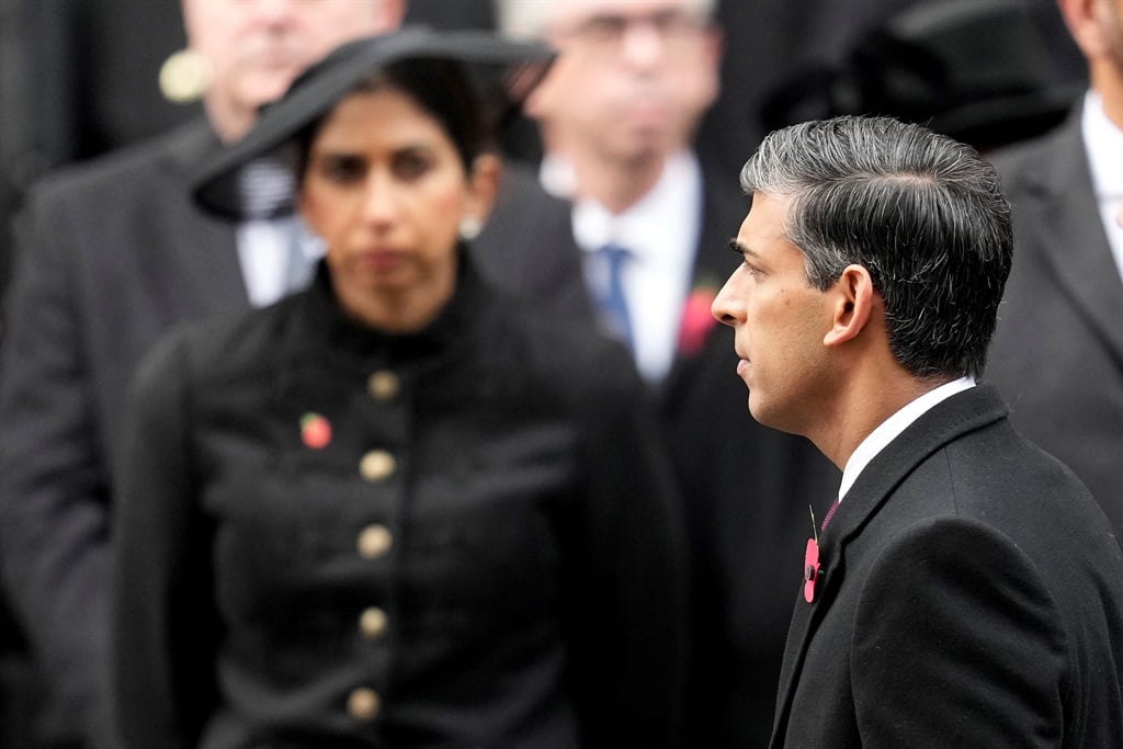 Then British Home Secretary Suella Braverman (L) looks on as Prime Minister Rishi Sunak (R) attends the National Service of Remembrance at the Cenotaph on Whitehall in central London, on 12 November 2023, on the weekend of a protest that saw her fired on Monday. (Photo by Kin Cheung / POOL / AFP)