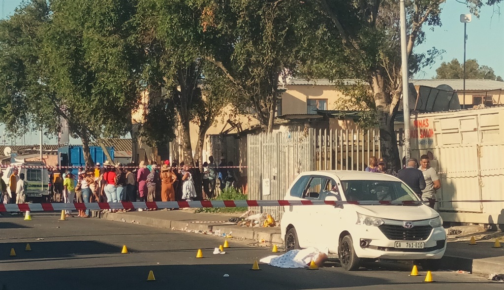One of the deceased covered with a blanket next to the Toyota Avanza at Ntlangano Crescent in Nyanga. 