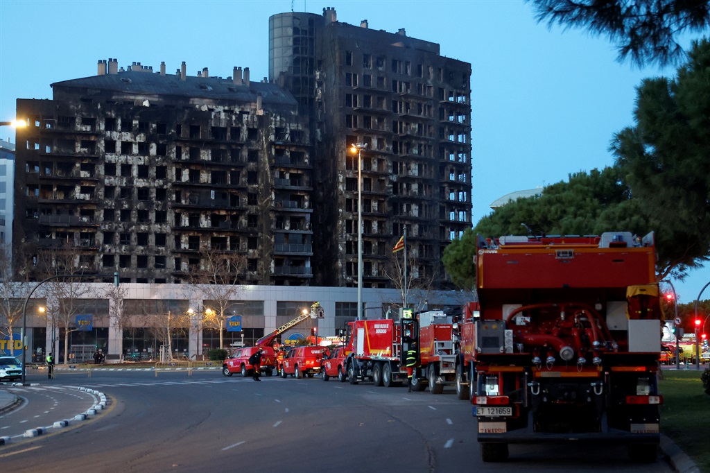 Firetrucks are parked next to the residential block ravaged by a huge fire that killed at least four people, in Valenci. (Photo by JOSE JORDAN / AFP)