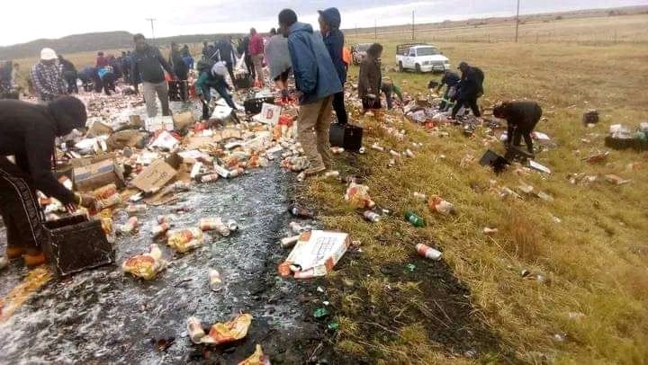 Residents helping themselves to alcohol after a truck lost control and crashed on the road because of rain. Photo by Joseph Mokoaledi 