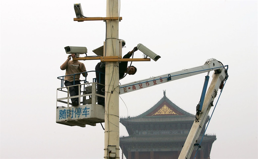 BEIJING - SEPTEMBER 28: Labourers adjust monitors 