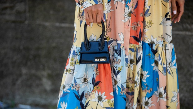 A guest is seen wearing dress with floral print, mini Jacquemus bag during Paris Fashion Week. Photo by Christian Vierig