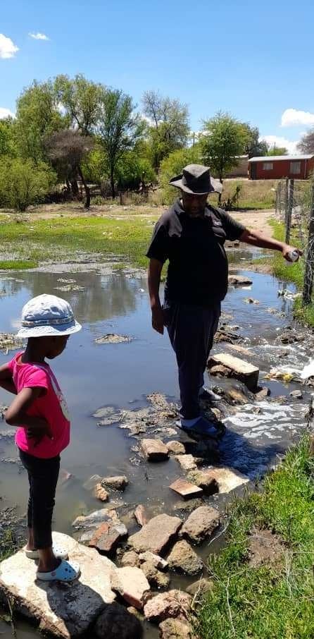 Benedict Sereko standing outside his yard where the sewage spills flow. Photo by Boitumelo Tshehle