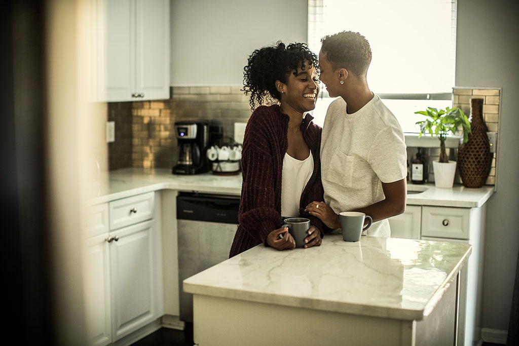 Lesbian couple embracing in kitchen
