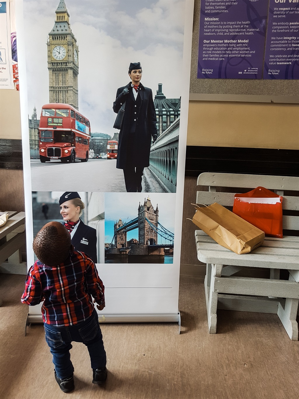 toddler looking up at a banner of british airways