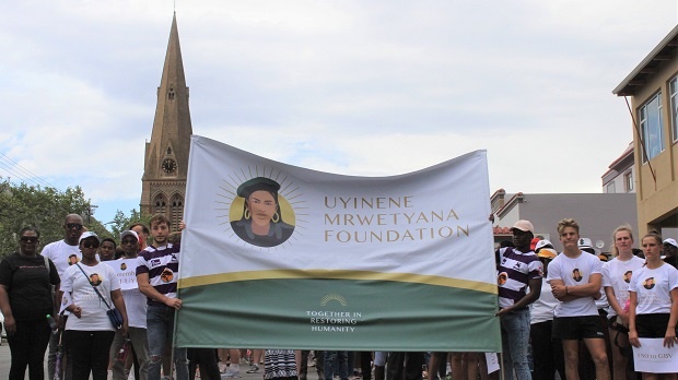 Rhodes Rugby players carry the Uyinene Mrwetyana Foundation banner during the march on Friday 29 November to mark its launch. (Steven Lang, Grocott's Mail)