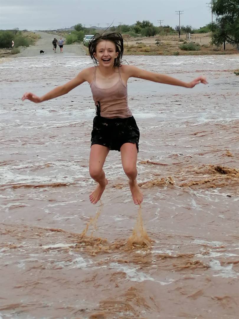 Telana Theron (14) baljaar in die rivier op die plaas Driekop in die Kenhardt-distrik nadat dit tussen 36 mm en 68 mm daar gereën het. Foto: Melanie Theron