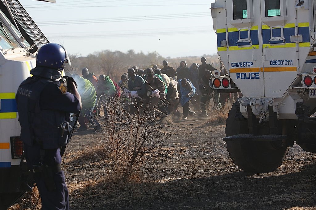 Police officers open fire on striking mine workers outside the Nkageng informal settlement on 16 August 2012 in Marikana. 