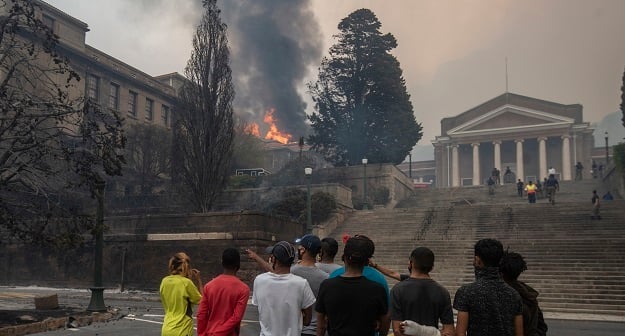 Students watch as a building burns at University of Cape Town.