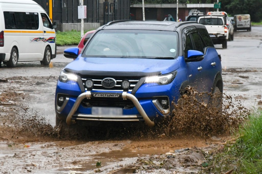 Vehicles try to get through mud in Riverside road on April 12, 2022 in Durban during heavy rains and flooding. 