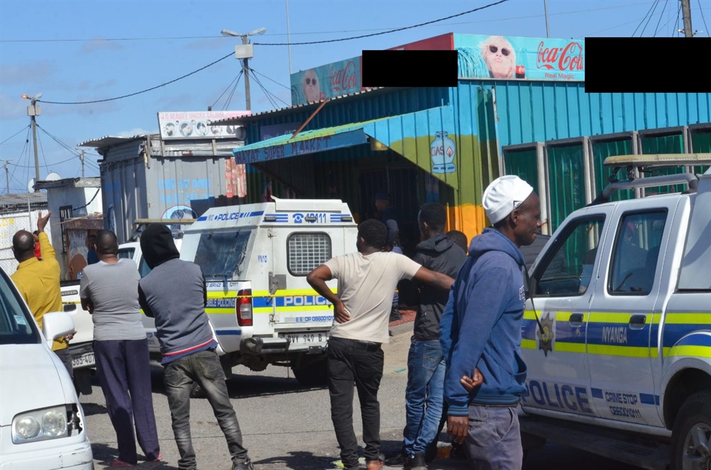 Residents at the scene where a shop owner was shot and killed in Philippi Brown’s Farm. Photo by Lulekwa Mbadamane