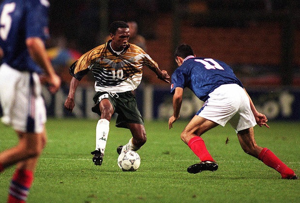 John Moshoeu get the better of Robert Pires in the friendly match against France.