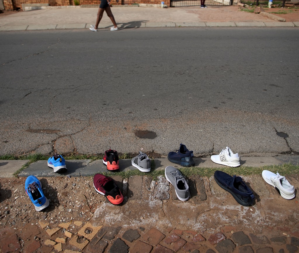  Mokgosi drying sneakers on the street pavement in