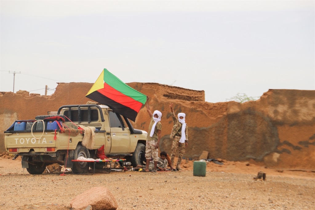 Fighters for The National Movement for the Liberation of Azawad (MNLA) hold up their flag in Kidal in August 2022. (Photo by SOULEYMANE AG ANARA / AFP)