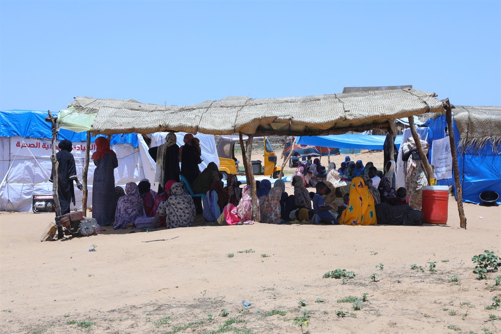 Sudanese patients wait under a makeshift shelter to be seen by medics at a refugee camp near Adre town in eastern Chad in August 2023. (Photo by Mohaned BELAL / AFP)