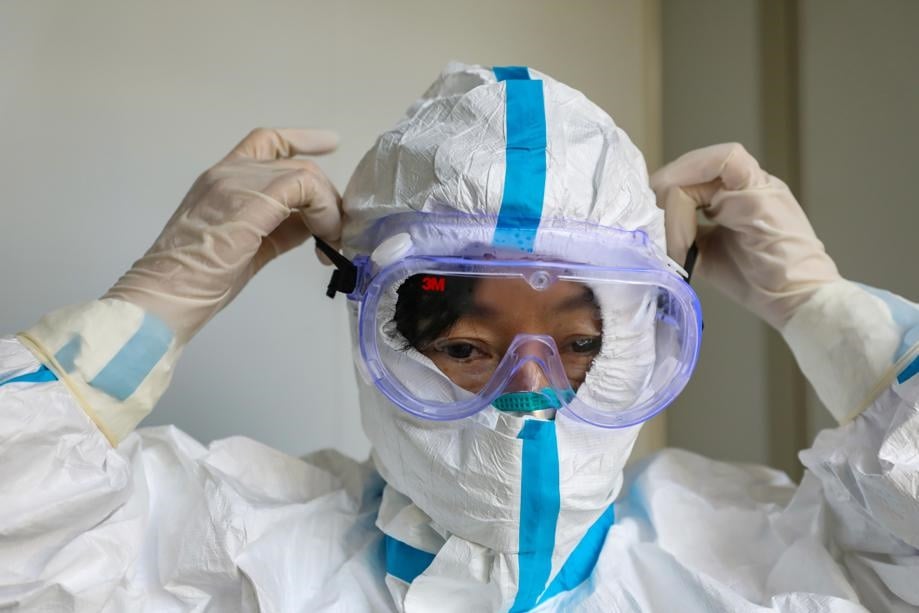 A doctor puts on protective goggles before entering the isolation ward at a hospital, following the outbreak of a new coronavirus in Wuhan, Hubei province, China on Thursday. Picture: China Daily via Reuters