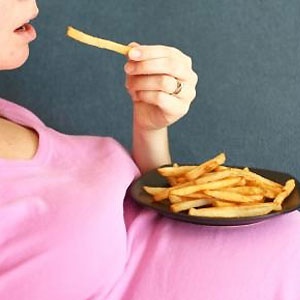 Pregnant woman eating potato chips. Source:iStockphoto