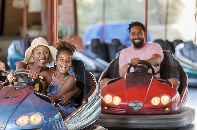 Mother and daughter spend a wonderful day while driving in bumper car.