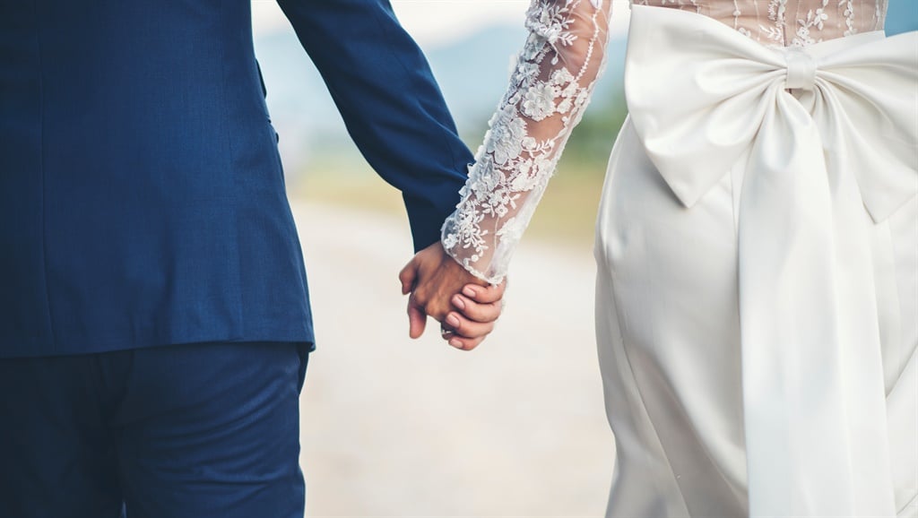 Illustration of married couple holding hands on wedding day.