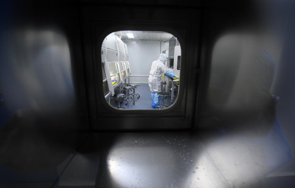 A worker in a protective suit examines specimens inside a laboratory following an outbreak of the novel coronavirus in Wuhan, Hubei province, China. Picture taken February 6, 2020. China Daily via Reuters
