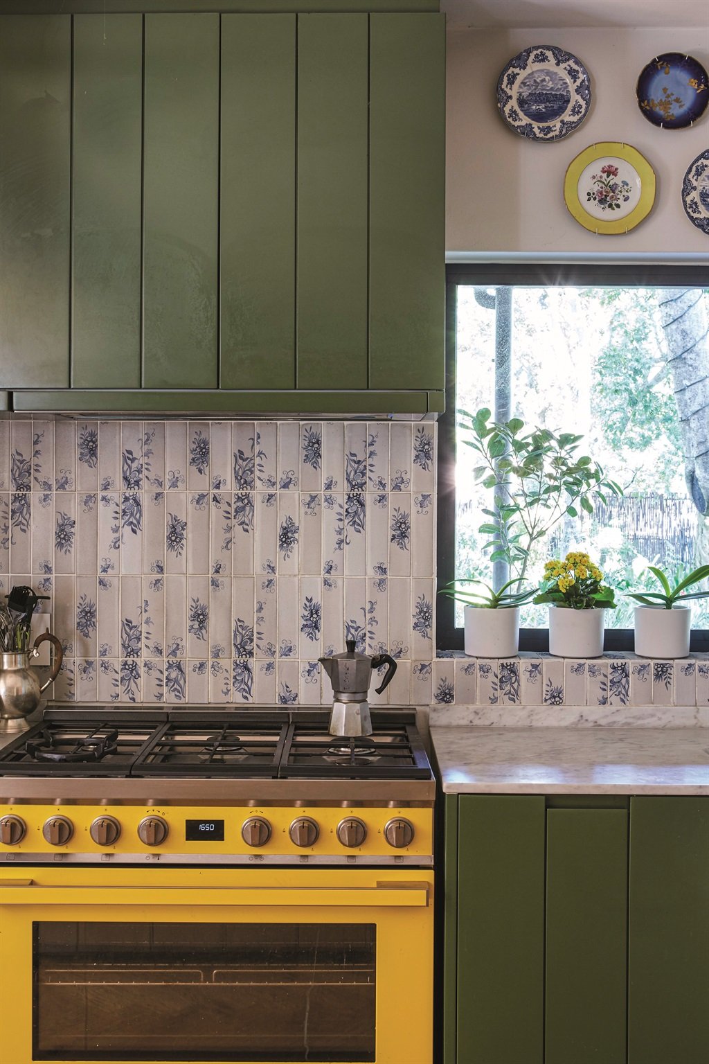 Bold yellow and green contrast with the delicate pattern on the tiles. Smeg stove from Modern Electric; tiles from Veelvlak Signature Surfaces