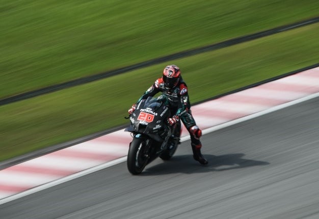 Petronas Yamaha SRT's French rider Fabio Quartararo dangles his leg as he breaks for a corner during the last day of the pre-season MotoGP winter test at the Sepang International Circuit in Sepang on February 9, 2020. MOHD RASFAN / AFP