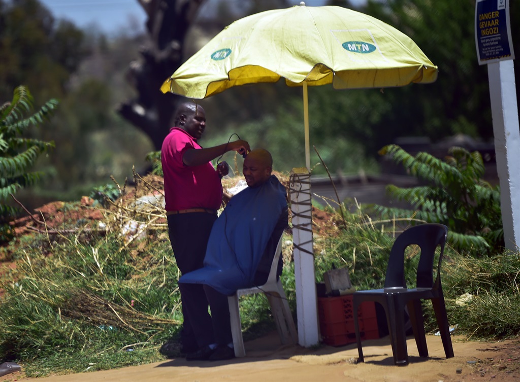 A roadside barber near Main Reef Road in Fleurhof is convenient for most people who need a quick haircut during the day. Photo by Trevor Kunene