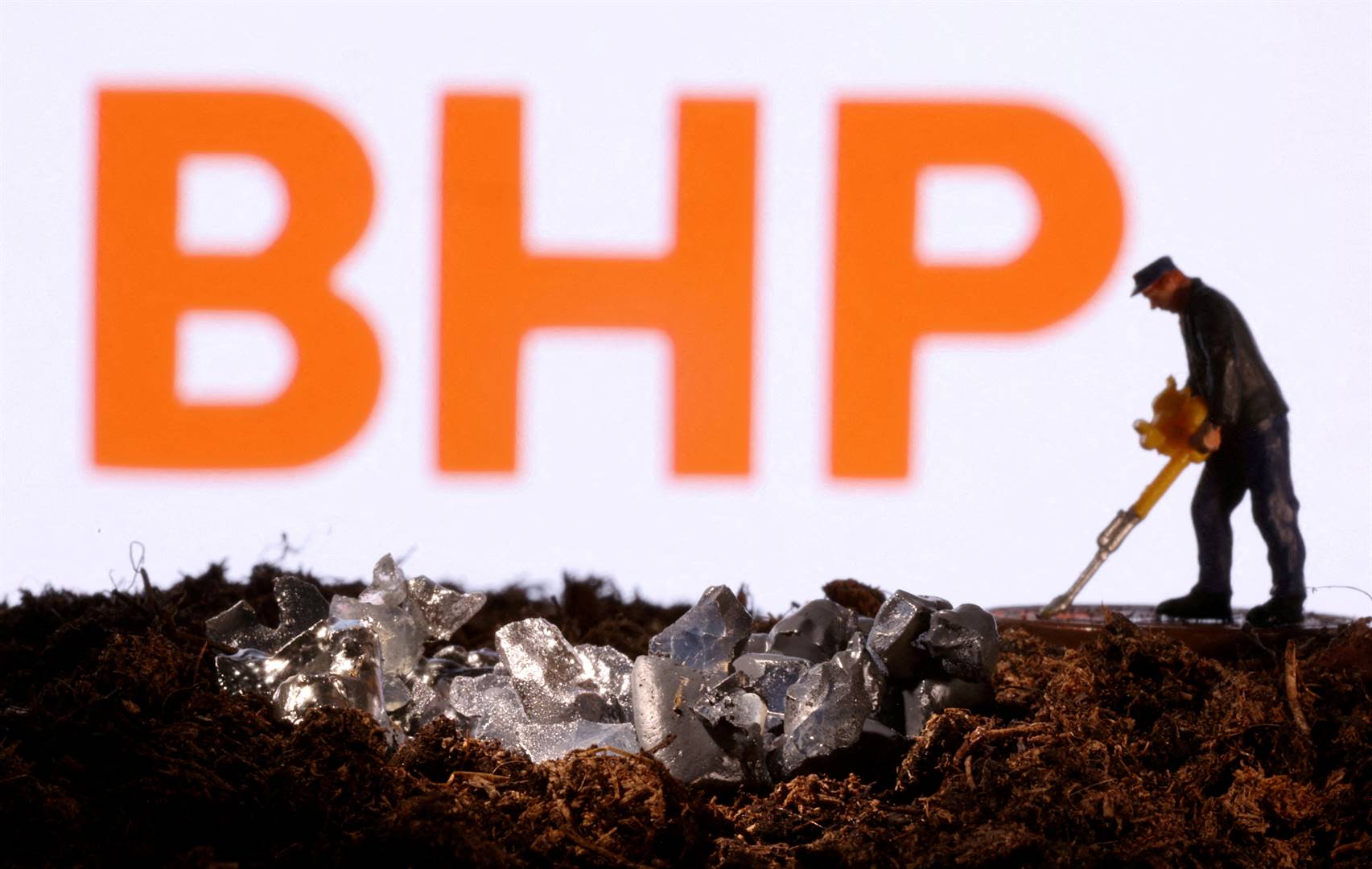 Die embleem van die Australiese mynreus BHP op die agtergrond van ’n miniatuur-diorama van mynbedrywighede. Die foto is in November 2021 geneem. Foto: Reuters
