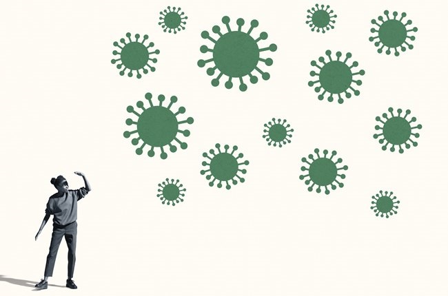 Full length of young woman shielding eyes while standing by large green coronavirus against white background